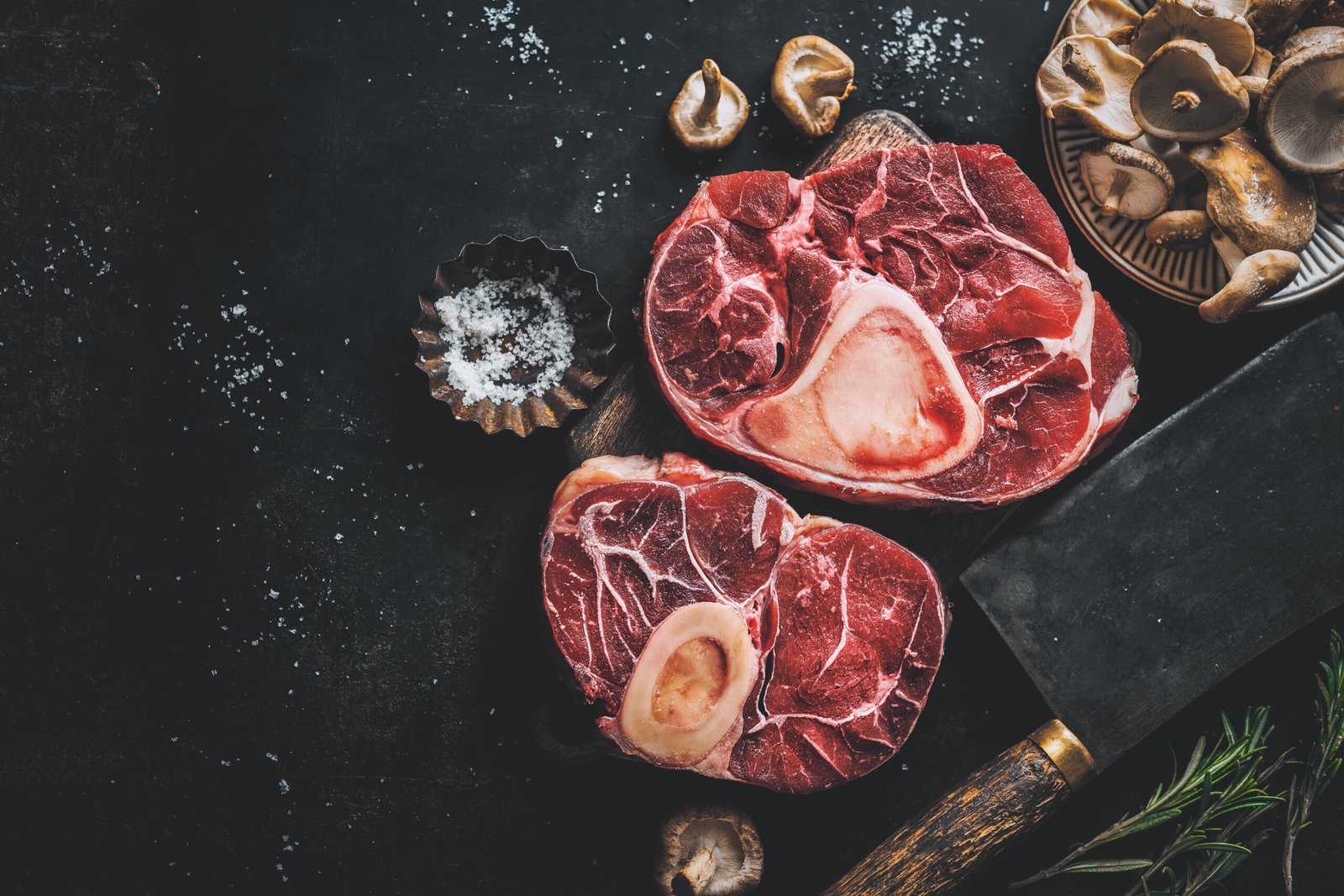Raw meat with vegetables and spices on dark vintage background. View from above.